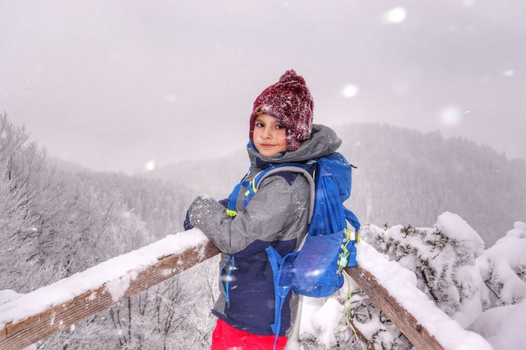 Dziecko na tarasie widokowym na niebieskim szlaku na najwyższy szczyt Pienin Małych - Wysoką, zima, sypiący śnieg