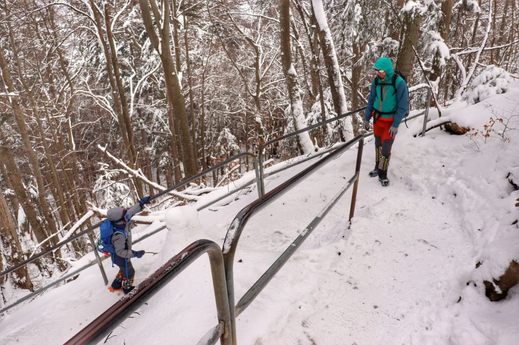 Dziecko z tatą wspinające się na Sokolicę, podejście na niebieskim szlaku zimą, metalowe barierki
