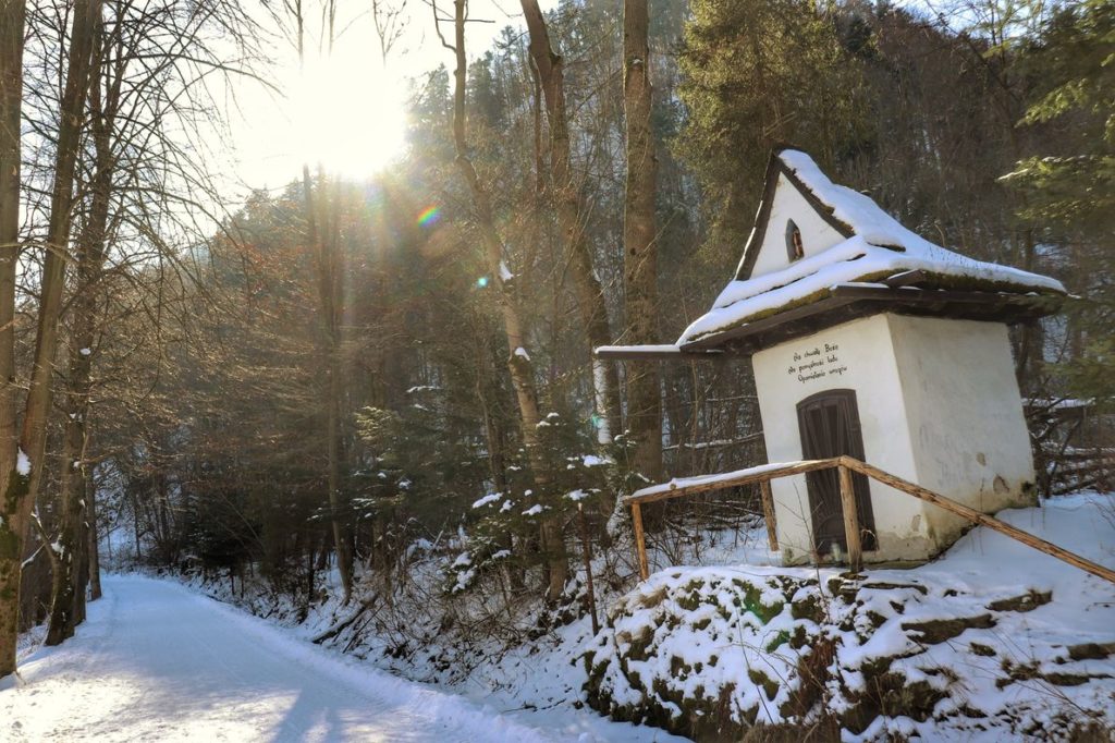 Kapliczka Świętej Kingi w Krościenku nad Dunajcem, zimowe popołudnie, szeroka, zaśnieżona droga na zielonym szlaku na Sokolicę