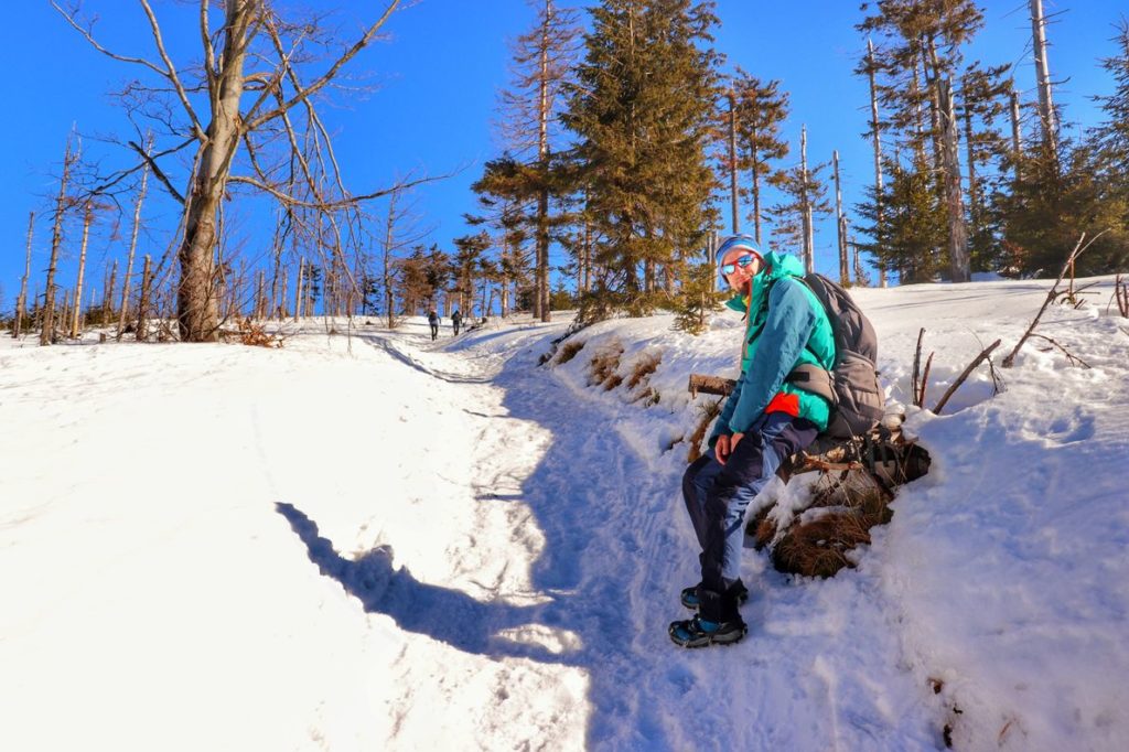 Turysta odpoczywający na szlaku czerwonym idącym na Malinowską Skałę, drzewa, śnieg
