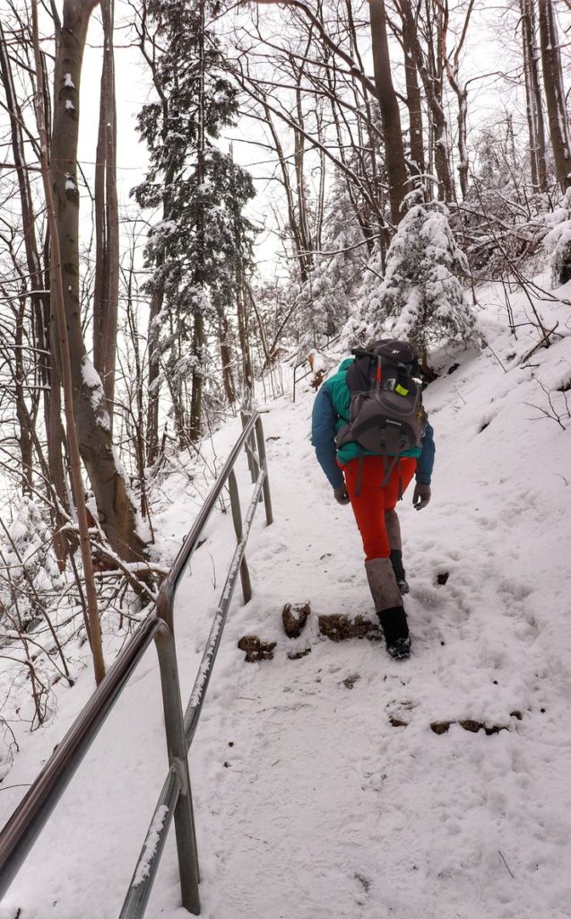 Turysta wychodzący na Sokolicę zimą - niebieski szlak, metalowe barierki