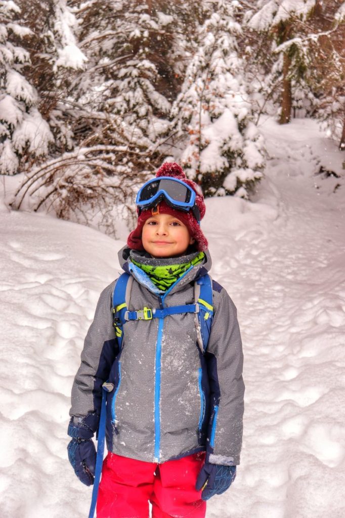 Uśmiechnięte dziecko idące zimą na szczyt w Pieninach Małych - Wysoką, leśna droga