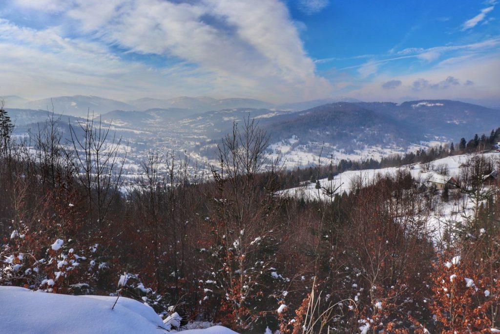 Widok na szczyty należące do Beskidu Żywieckiego z punktu widokowego na podejściu na niebieskim szlaku z Rajczy, piękny, zimowy dzień