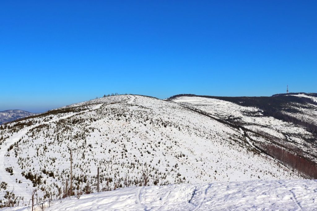 Widok na zaśnieżony najwyższy szczyt Beskidu Śląskiego - Skrzyczne z Malinowskiej Skały
