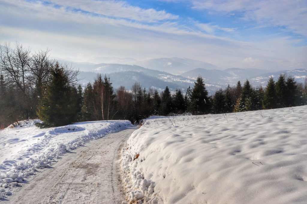 Zima w Rajczy na niebieskim szlaku na Halę Boraczą, w oddali widok na Beskid Żywiecki