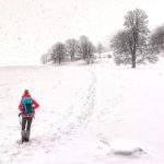 Turystka idąca wzdłuż Polany pod Wysoką - zima, duże ilości śniegu