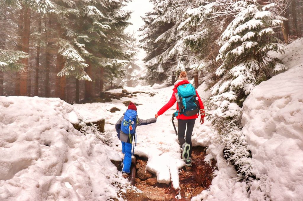 Turystka z dzieckiem, leśna droga w Karkoszach, śnieg zalegający na szlaku