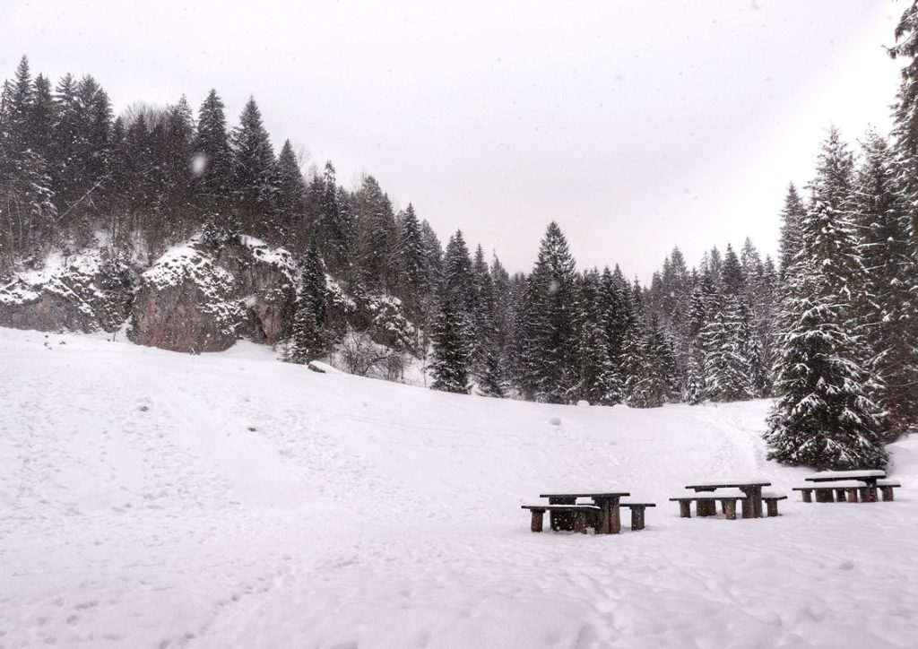 Zima na Polanie Dubantowskiej w Małych Pieninach, drewniane stoliki z ławkami, sypiący śnieg