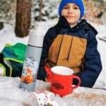 Dziecko, drewniany stół, ławki, droga leśna na szlaku żółtym w Rabce Zaryte, zima