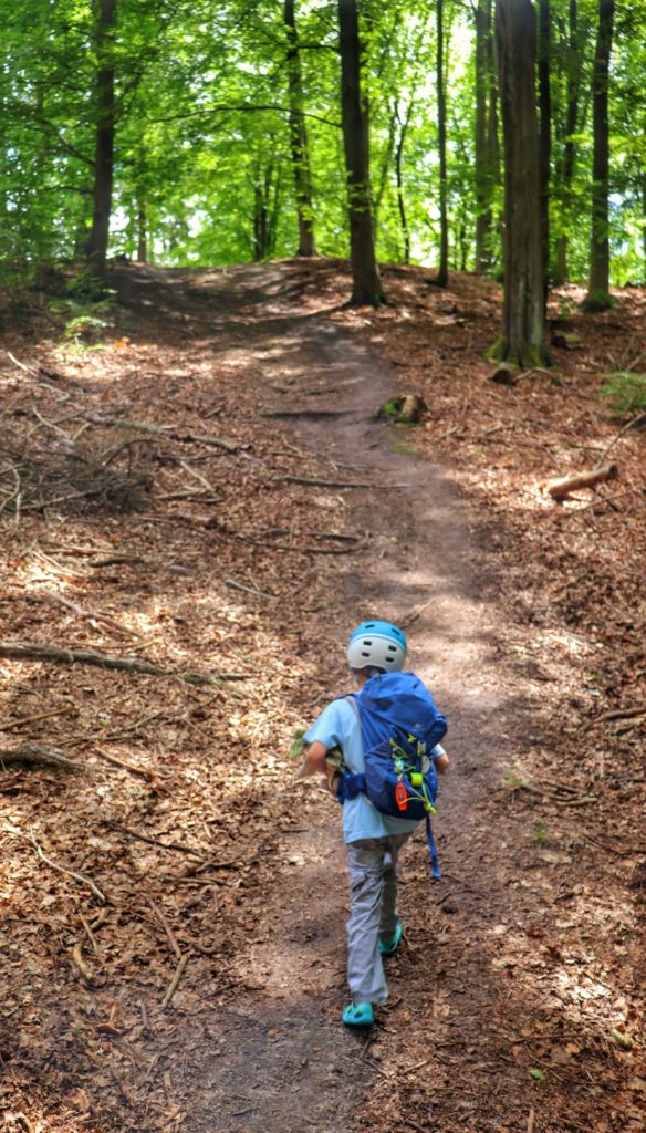 Dziecko idące pod górę na żóltym szlaku w Koszalinie prowadzącym przez las