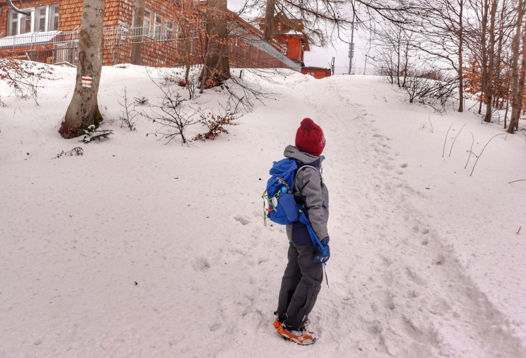 Dziecko na ostatnim, krótkim podejściu na czerwono - żółtym szlaku do schroniska na Luboniu Wielkim, wkoło zalega sporo śniegu