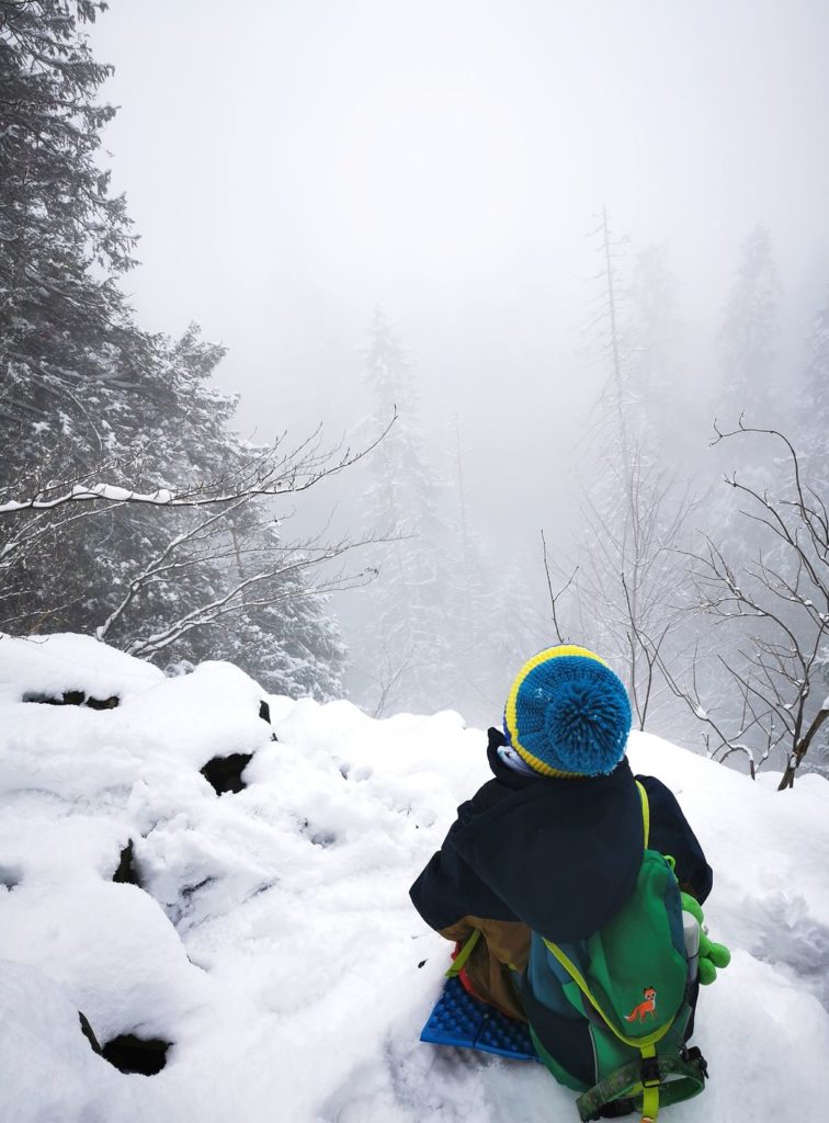 Dziecko odpoczywające na zaśnieżonych skałach , mgła, zimowe popołudnie- Perć Borkowskiego szlak żółty