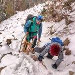 Dziecko wspinające się zimą po skałach na Perci Borkowskiego, mężczyzna z sankami