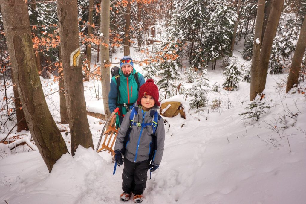 Dziecko z tatą idący żółtym szlakiem na Luboń Wielki, droga leśna, zima