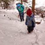 Dziecko z tatą pokonujący podejście idące w stronę Perci Borkowskiego, śnieg
