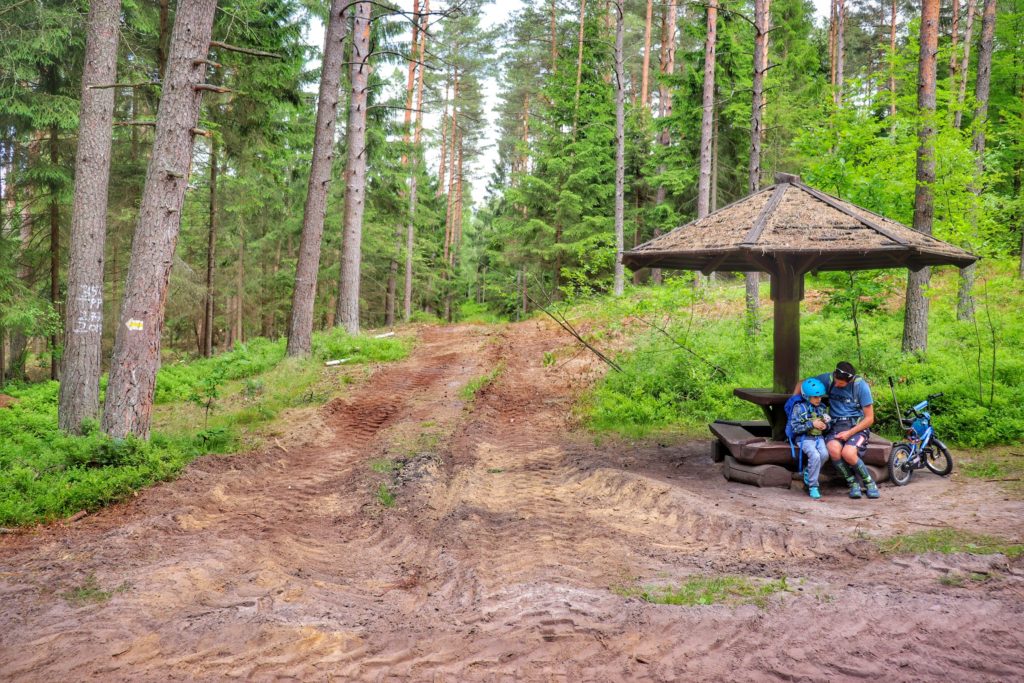Mężczyzna z dzieckiem odpoczywający na ławce w lesie - Pętla Tatrzańska Koszalin (żółty szlak)