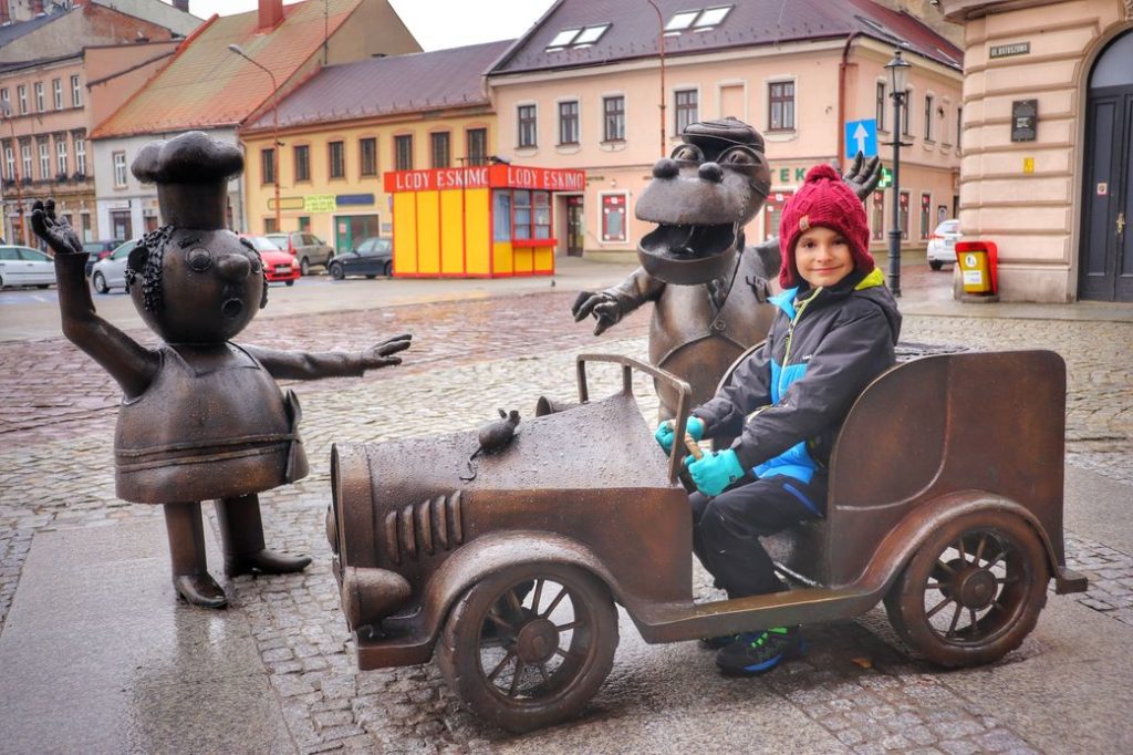 Rzeźba Smok Wawelski i Bartolini Bartłomiej), dziecko siedzące w samochodziku