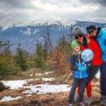 Szczęśliwa rodzina pozująca na tle Babiej Góry na czarnym szlaku idącym z Zawoi, pochmurny, wiosenny dzień