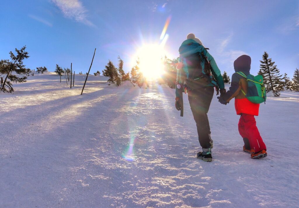 Turystka z dzieckiem na zimowym szlaku biegnącym na Śnieżne Kotły