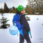 Uśmiechnięte dziecko na pokrytej śniegiem polanie w Beskidzie Żywieckim