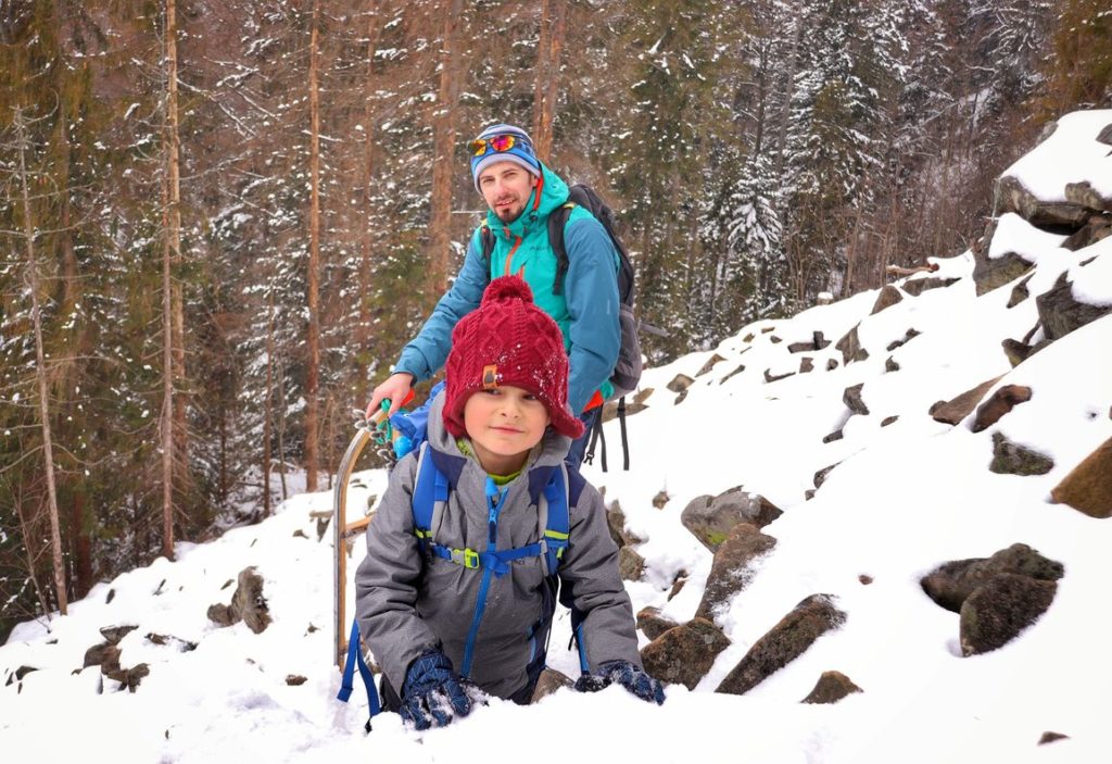 Zadowolone dziecko z tatą na Perci Borkowskiego zimą