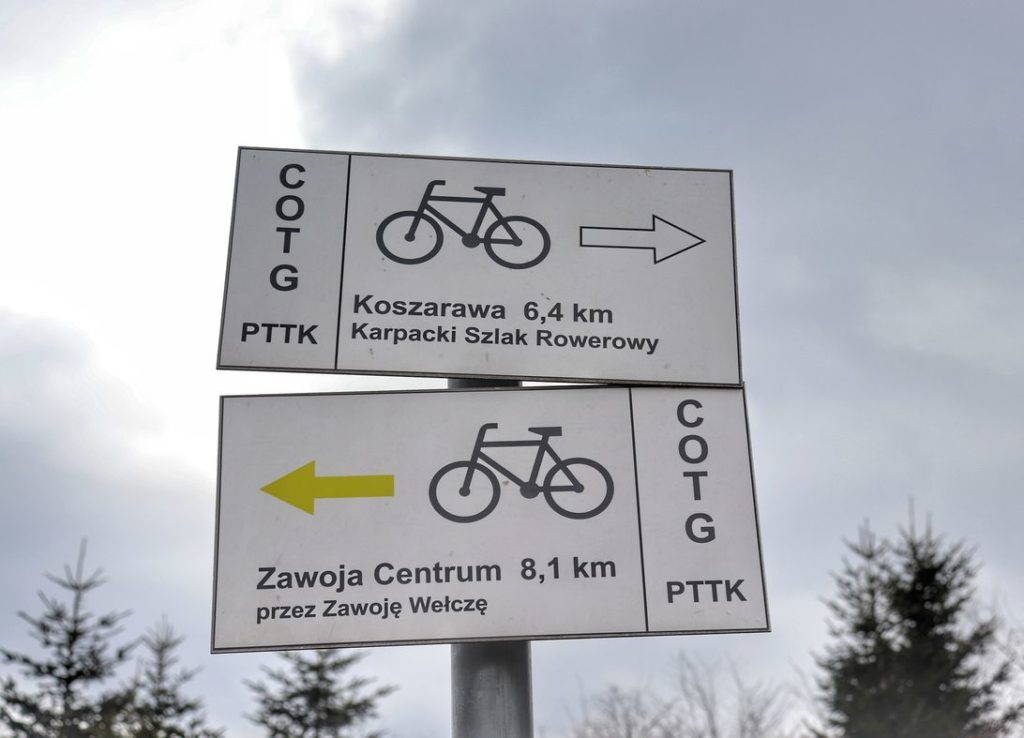 Białe tabliczki, na których są opisane szlaki rowerowe idące z Przełęczy Klekociny