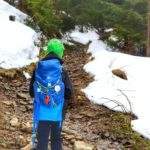 Dziecko, kamienista ścieżka, po której płynie potok, las