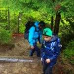 Dziecko z tatą na żółtym szlaku idącym na Rycerzową w Beskidzie Żywieckim, pnąca się w górę ścieżka leśna