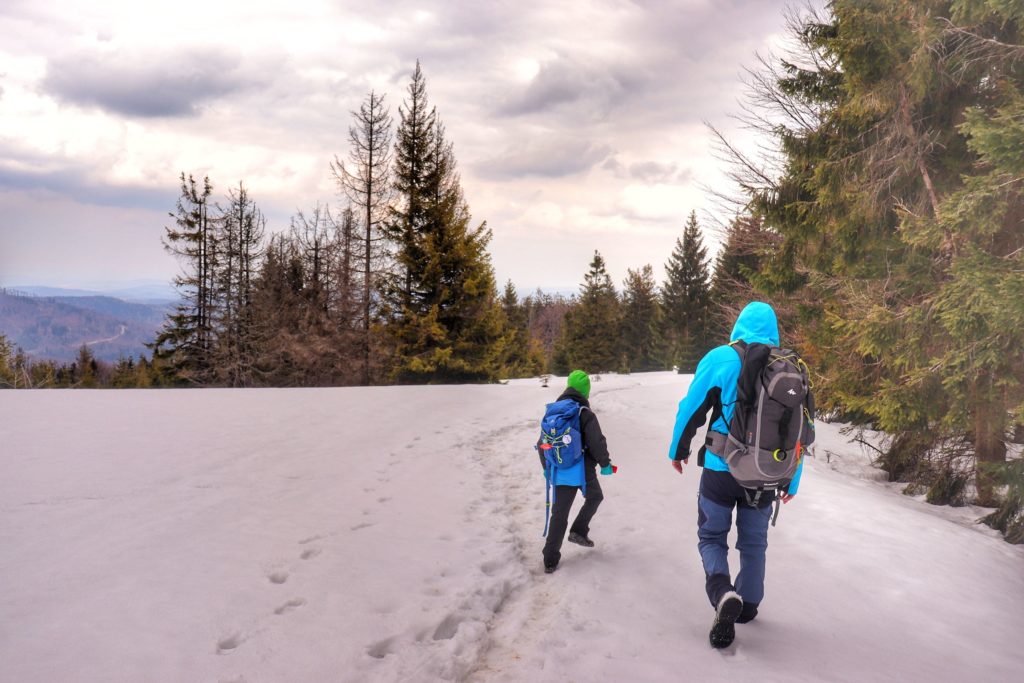 Mężczyzna z dzieckiem na czarnym szlaku prowadzącym z Hali Kamińskiego w stronę Zawoi, śnieg