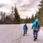 Mężczyzna z dzieckiem na czarnym szlaku prowadzącym z Hali Kamińskiego w stronę Zawoi, śnieg