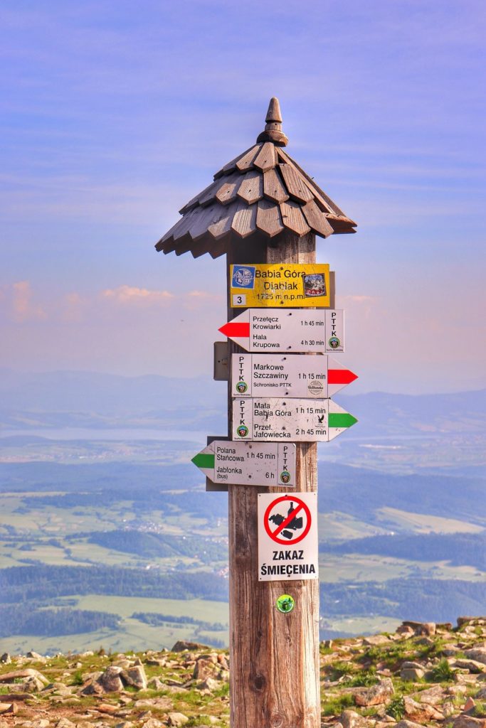 Szczyt Babiej Góry, słup z drogowskazami oraz z żółtą tabliczką z napisem Babia Góra - Diablak