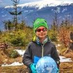 Szczęśliwe dziecko trzymające urodzinowy, niebieski balon, na którym jest cyfra 7, w tle Królowa Beskidów - Babia Góra