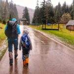 Turysta z dzieckiem w Gorczańskim Parku Narodowym, szeroka, asfaltowa droga, deszczowy dzień