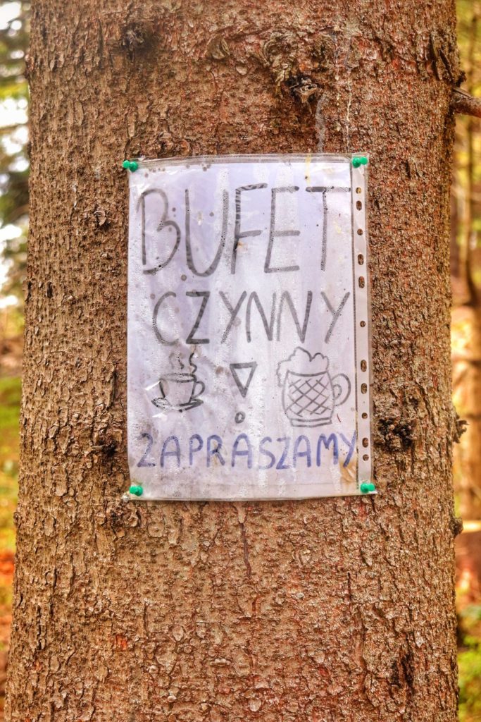 Kartka w przezroczystej folii z napisem BUFET CZYNNY wisząca na drzewie 2 minuty drogi od Bacówki na Krawcowym Wierchu