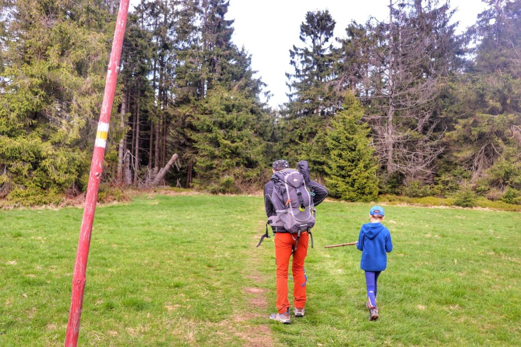 Turysta z dzieckiem na żółtym szlaku idącym na szczyt Krawców Wierch