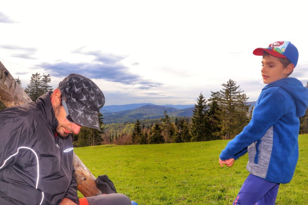Turysta z dzieckiem odpoczywający na polanie - Krawców Wierch
