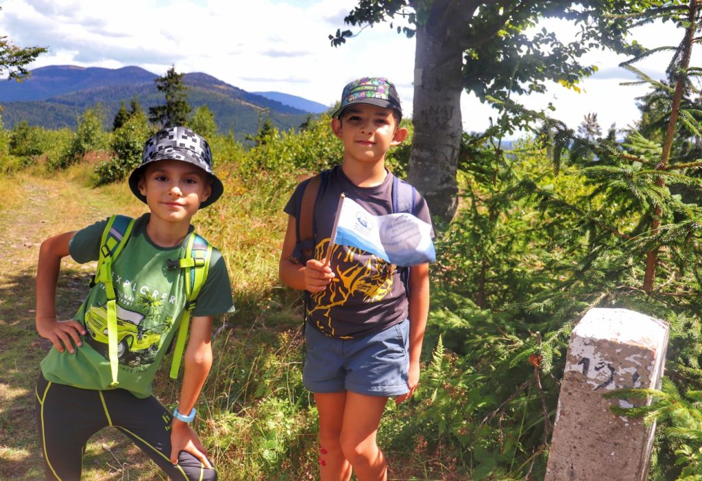 Szczyt Sucha Góra w Beskidach, dzieci z flagą akcji Zdobywamy Szczyty dla Hospicjum