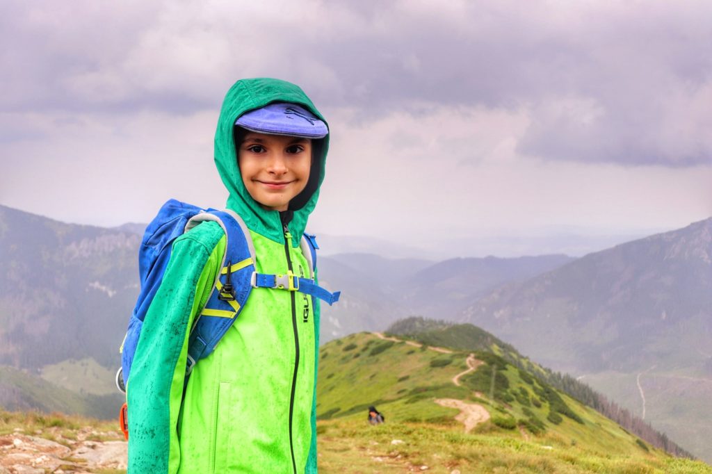 Uśmiechnięte dziecko na tle Tatr - szczyt Trzydniowiański Wierch, zachmurzony, letni dzień