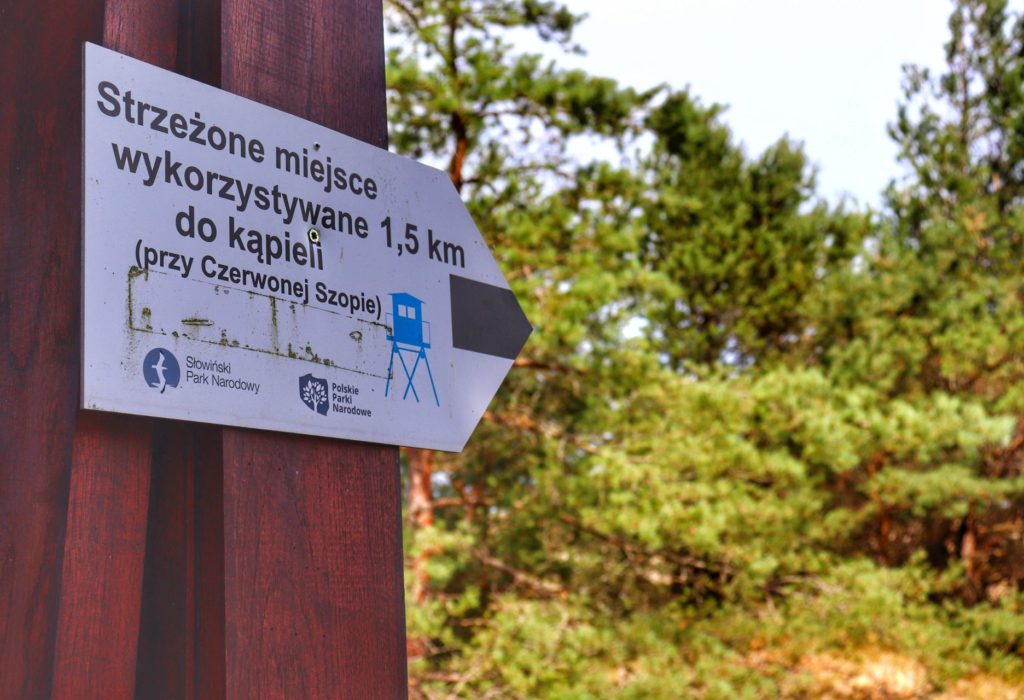 Tablica wskazująca drogę do strzeżonego miejsca wykorzystywanego do kąpieli (przy Czerwonej Szopie - Słowiński Park Narodowy)
