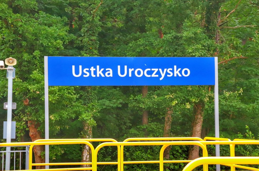 Niebieska tablica z białym napisem - Ustka Uroczysko na stacji kolejowej