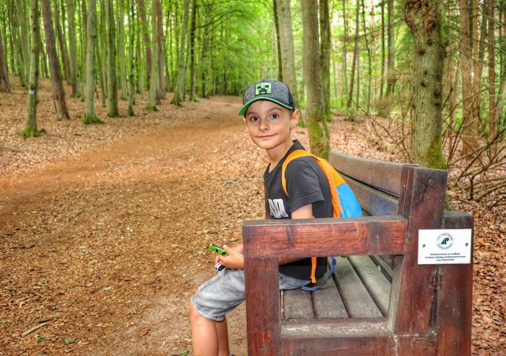 Uśmiechnięte dziecko odpoczywające na drewnianej ławce - Słowiński Park Narodowy