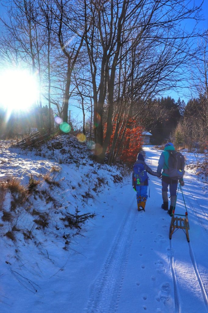 Dziecko z tatą, stroma droga w Milówce, zimowy, słoneczny dzień