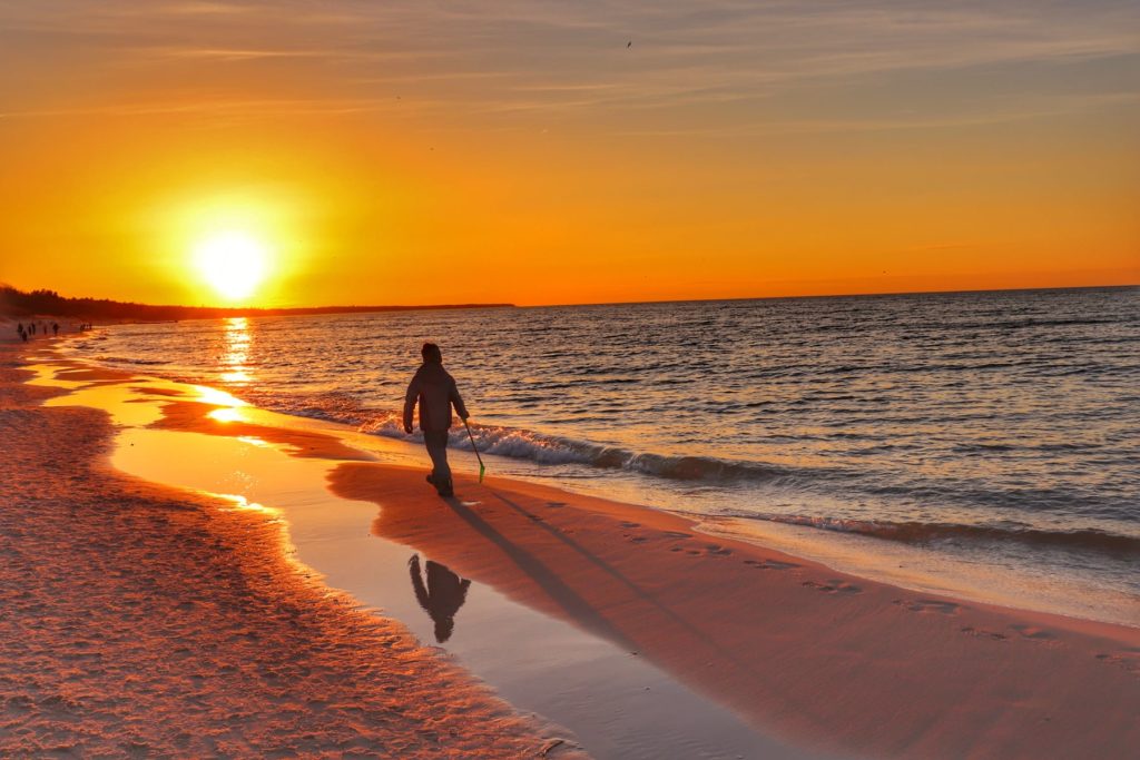 Dziecko idące brzegiem morza podczas zachodu słońca - Kołobrzeg