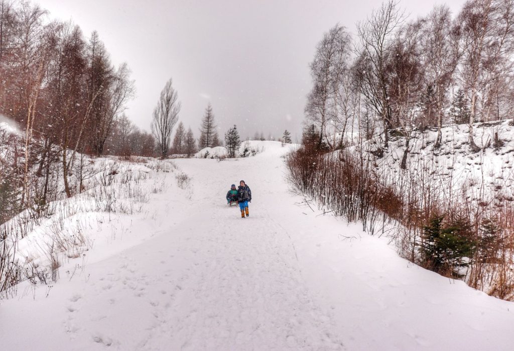 Szeroka droga schodząca do Kamieniołomu w Kozach, dziecko z tatą, zimowe popołudnie