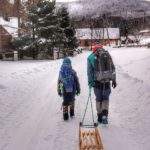 Turysta ciągnący drewniane sanki, dziecko, droga, Stryszawa Roztoki