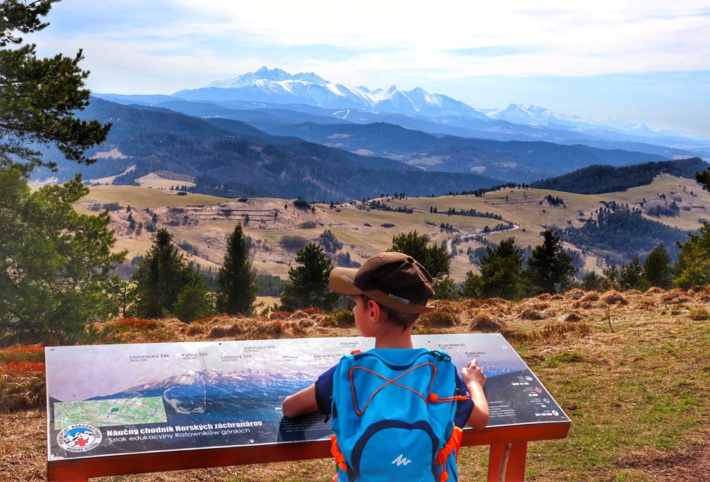 Dziecko na szczycie Wysoki Wierch w Małych Pieninach, tablica opisująca panoramę rozciągającą się ze szczytu, widok na tatrzańskie szczyty