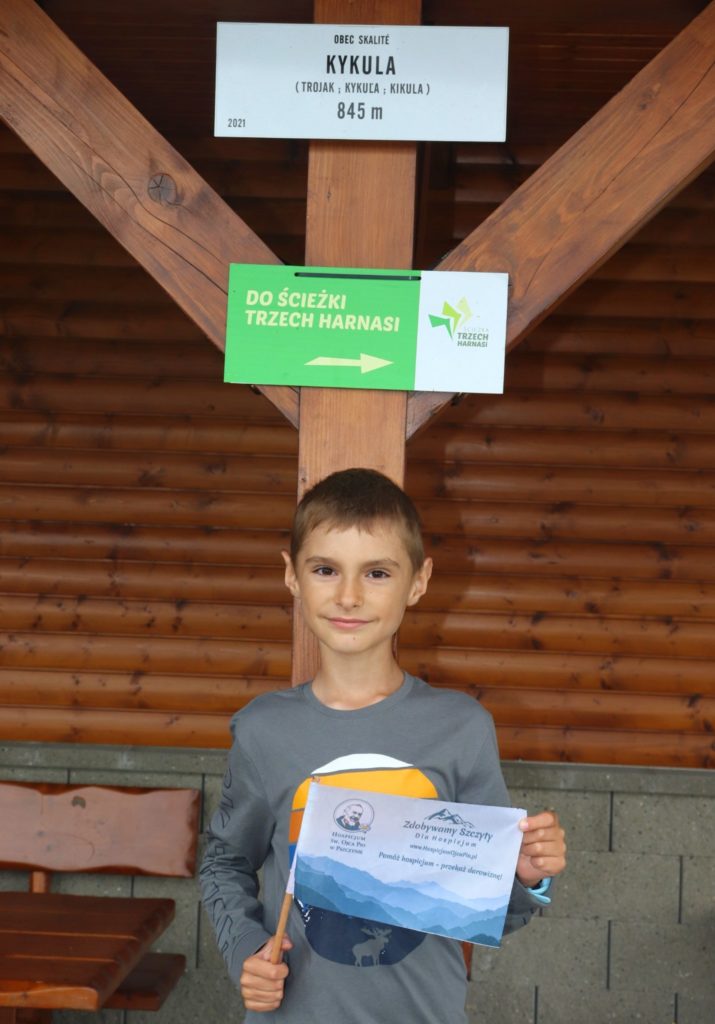 Uśmiechnięte dziecko z chorągiewką akcji zdobywamy szczyty dla hospicjum na słowackim szczycie Kykula położonym 845 m n.p.m.