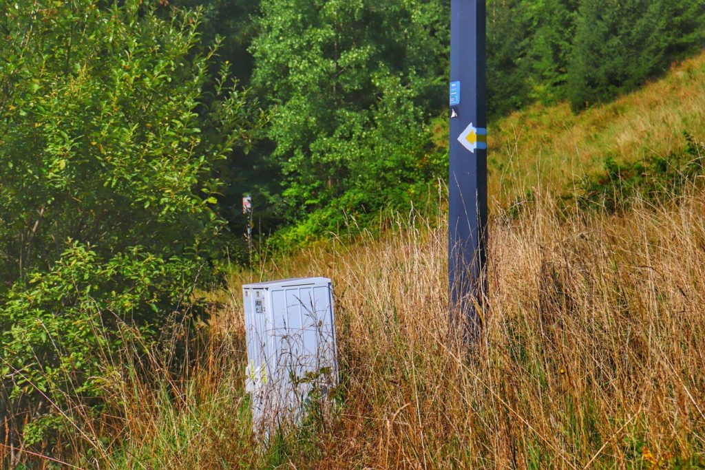 Żółta strzałka na słupie wskazująca kierunek szlaku żółtego idącego do Trójstyku granic - Jaworzynka