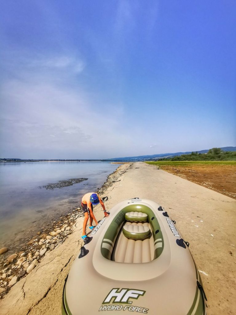 Dziecko, dmuchany ponton, brzeg Jeziora Czorsztyńskiego, piękny słoneczny dzień, niebieskie niebo