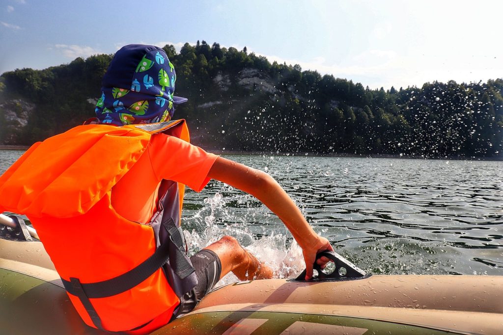 Dziecko w kamizelce ratunkowej na pontonie chlapiące wodą - Jezioro Czorsztyńskie